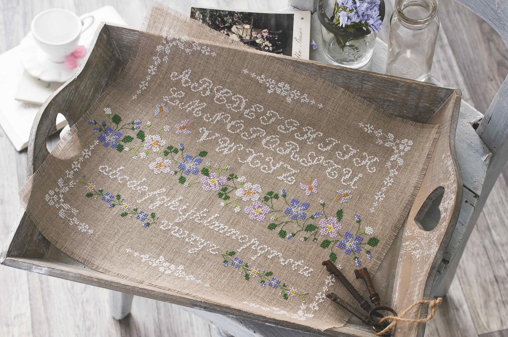 Grille broderie point de croix : sampler fleuri avec alphabet, motif 179×130 pts, 32,5×23,6 cm. Symboles + couleurs DMC, 6 pages.