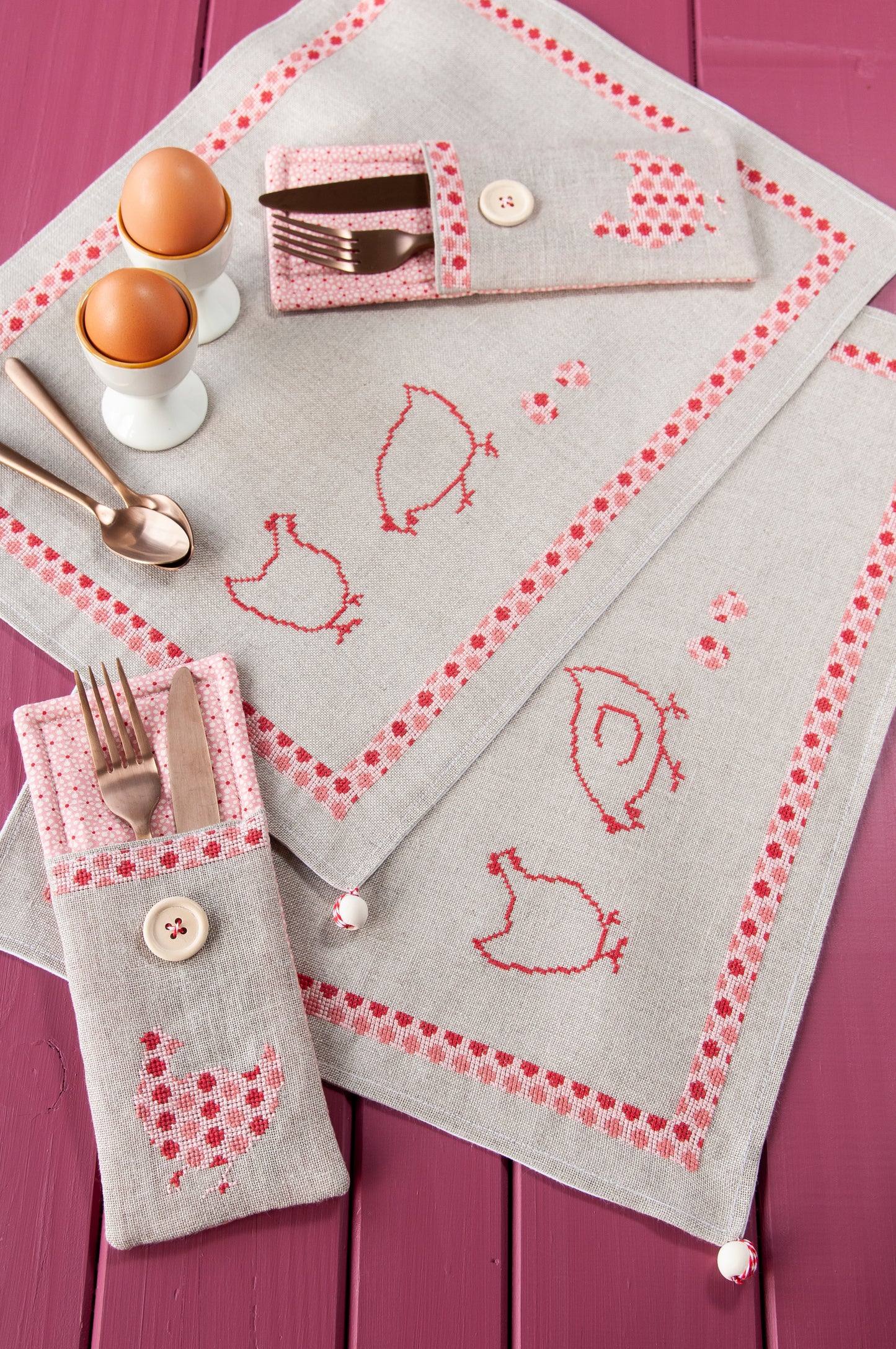 Grille de broderie point de croix « Sets de table poules » : poules à carreaux et à pois sur lin blanc 11 fils. DMC, 10 pages – set de table et pochette à couverts.