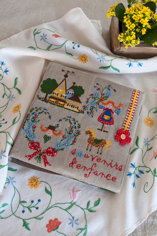 Grille de broderie point de croix « Souvenirs d'enfance » par Lili Violette : cahier brodé sur toile bis 14 fils. DMC, 6 pages, motif 31,09 x 33,27 cm.