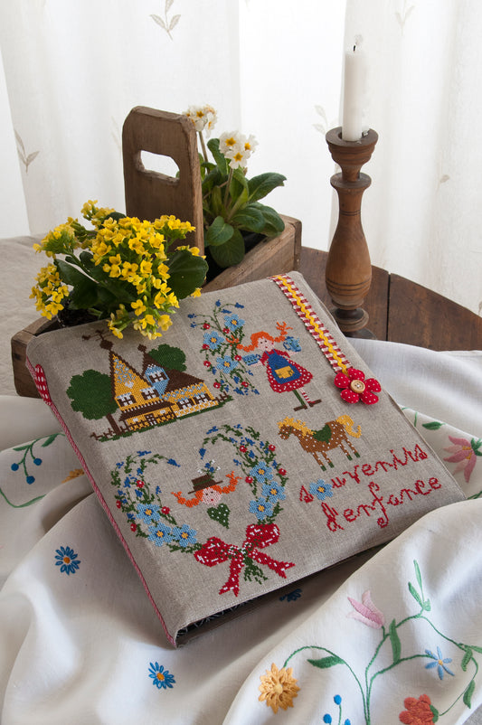 Grille de broderie point de croix « Souvenirs d'enfance » par Lili Violette : cahier brodé sur toile bis 14 fils. DMC, 6 pages, motif 31,09 x 33,27 cm.