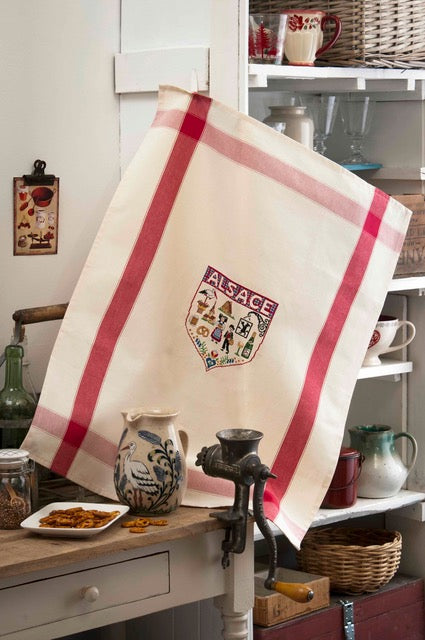 Grille de broderie point de croix : torchon Alsace avec bretzel, kouglof et cigogne, 103x118 points sur 4 pages. Symboles et couleurs DMC, sur Aïda blanc.