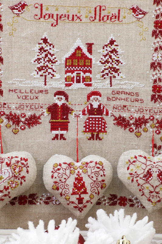 Grille de point de croix Un amour de Noël : sapins et cœurs sur lin bis. Motif 146 x 150 points. Références DMC sur 4 pages.