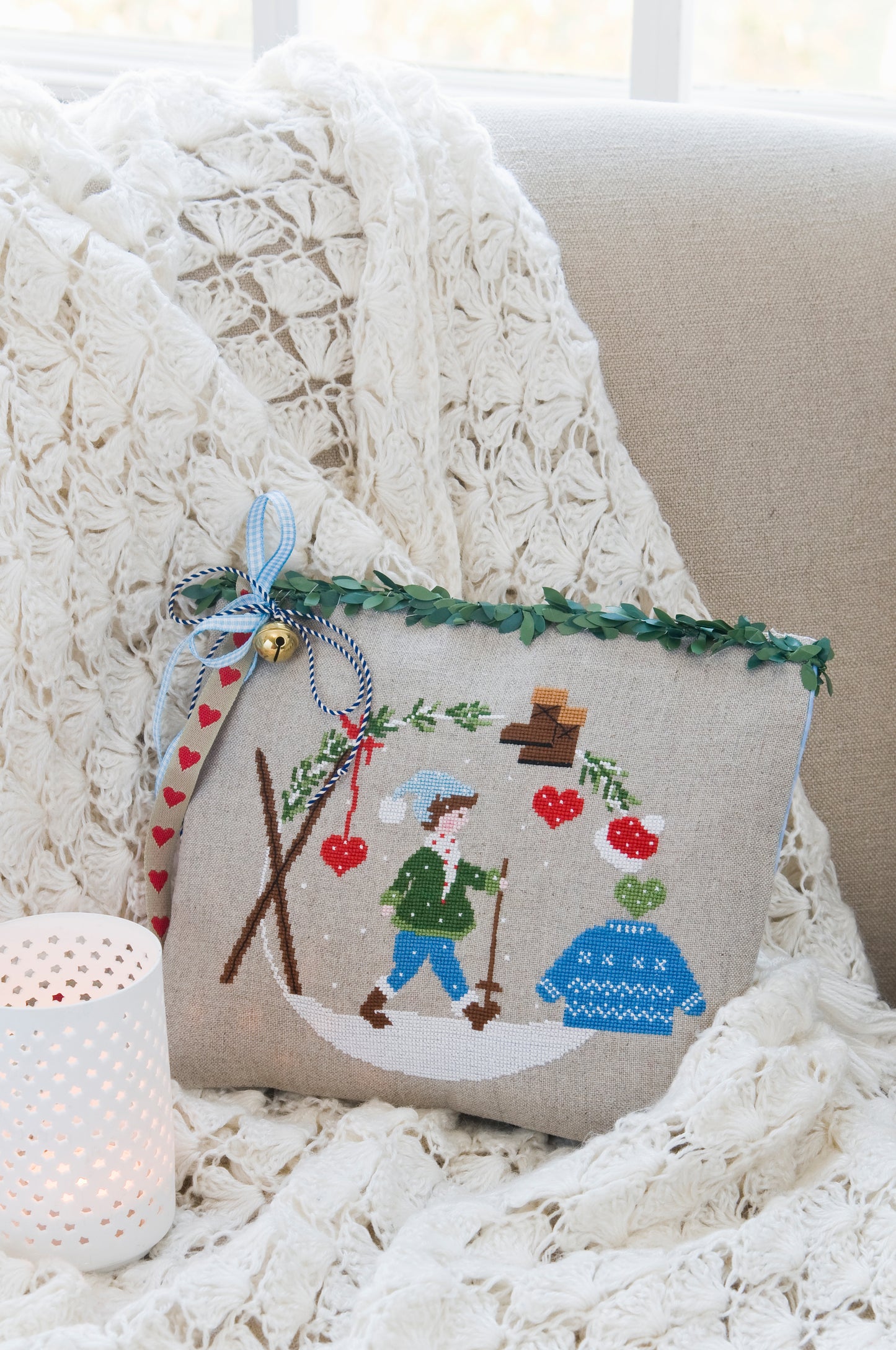 Grille de broderie point de croix : coussin hiver ambiance chalet de montagne. Motif 133 x 109 pts, imprimé couleur (Réf. DMC) sur 6 pages. Illustration Lili Violette. 