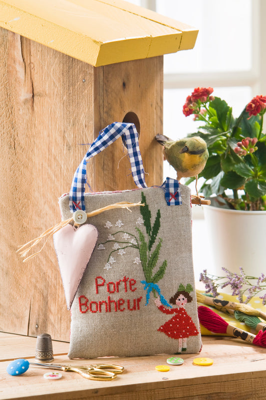 Grille de broderie point de croix : petit sachet porte-bonheur muguet du 1er mai. Motif 111 x 77 pts, imprimé couleur (Réf. DMC) sur 6 pages. Illustration Lili Violette.