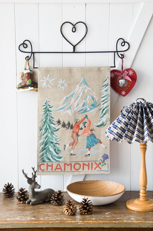 Grille de broderie point de croix : affiche Chamonix, scène de patinage hivernal. Motif 157 x 205 pts, imprimé couleur (Réf. DMC) sur 6 pages. Illustration M. Bonnin.