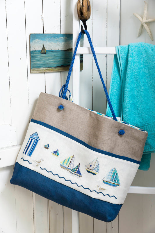 Grille broderie point de croix : sac de plage été. 4 pages, symboles et couleurs DMC. Lin 11 fils blanc. Sac terminé 43 x 55 cm.
