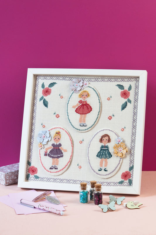 Grille point de croix : petites filles en robes chics dans cadre ovale sur lin clair. Motif 160 x 160 points (29,09 x 29,09 cm), 6 pages, DMC.