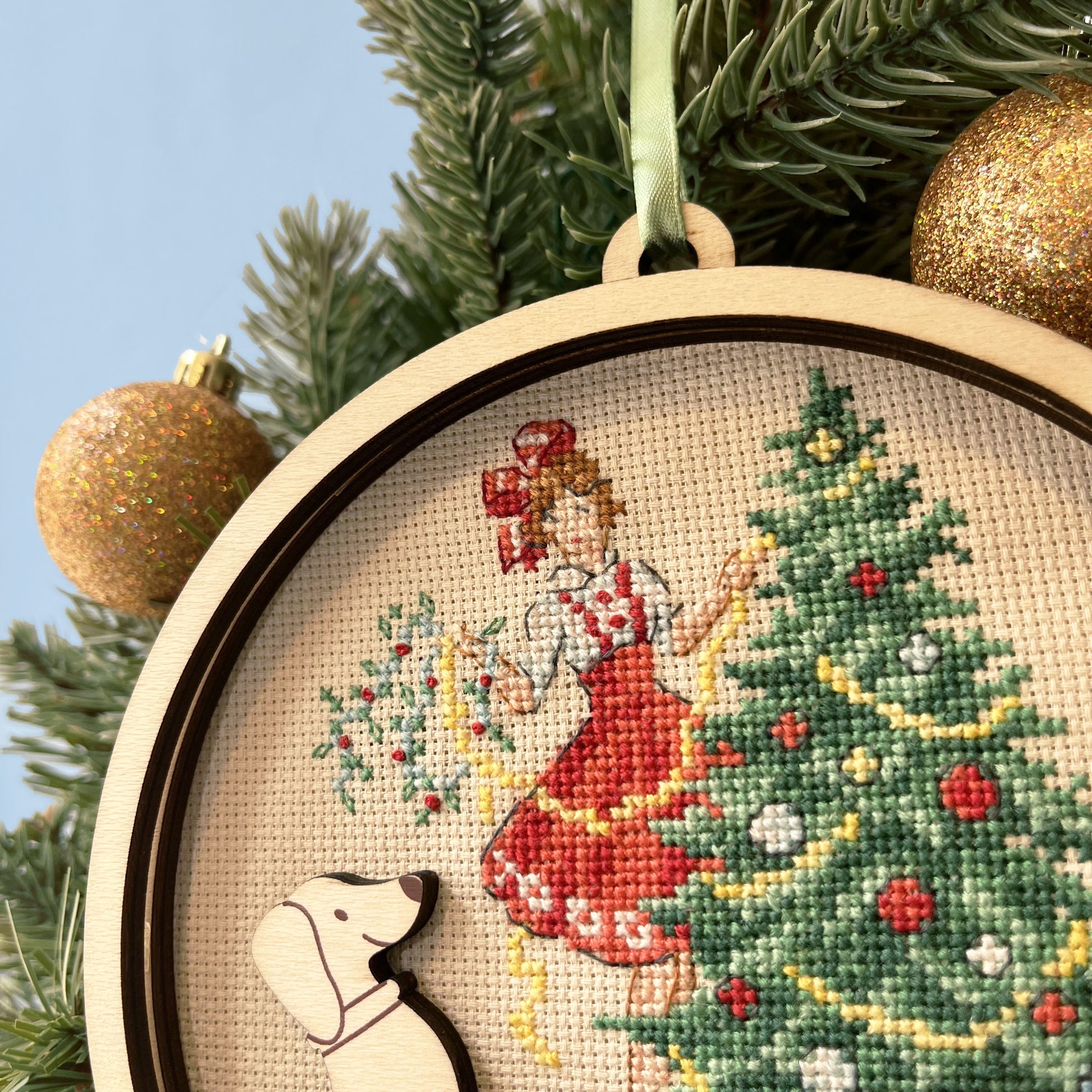 Grille point de croix : suspension de Noël avec teckels, sapin et cadeaux. 79×72 pts, sur Aïda 7 pts/cm ou lin 14 fils/cm. 6 pages couleur, réf. DMC.