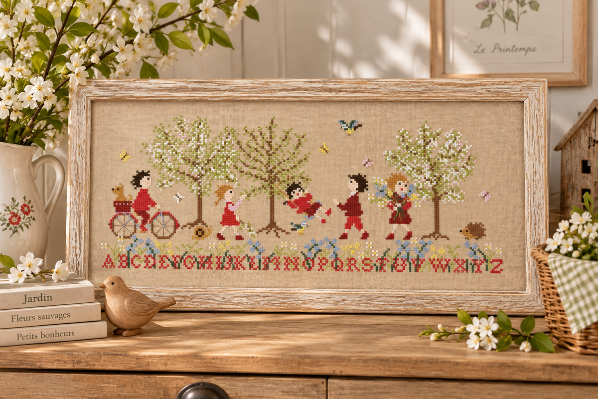 Grille point de croix inédite de Perrette Samouiloff : Frise le Jardin des lettres, 209 × 83 points, fleurs printanières et alphabet. Création Point de Croix.
