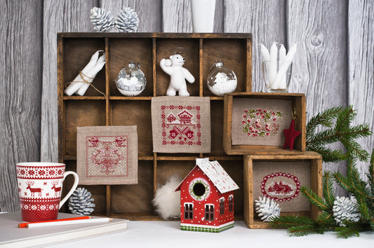 Petits motifs hivernaux brodés sur toile Aïda naturelle, signés M.A. Réthoret-Melin. Chalets, oiseaux et cœurs nordiques en rouge et blanc, esprit montagne et Noël.