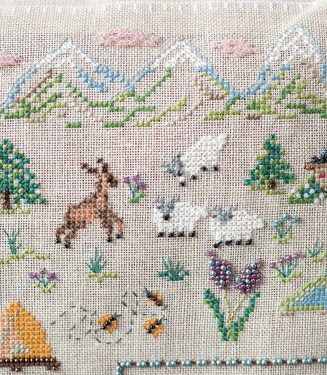 Grille de point de croix Le coussin des alpages : chamois, edelweiss et perles sur lin 12 fils. 127 x 150 points. Références DMC sur 6 pages.