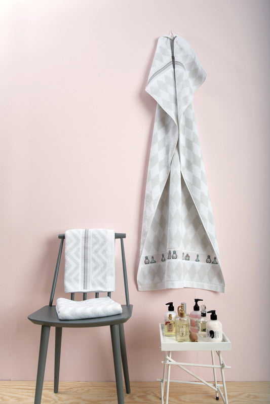 Grille de point de croix Linge de bain : dentelles et flacons de parfum sur Aïda 5,5 pts blanc. Plusieurs motifs inclus. Références DMC sur 6 pages.