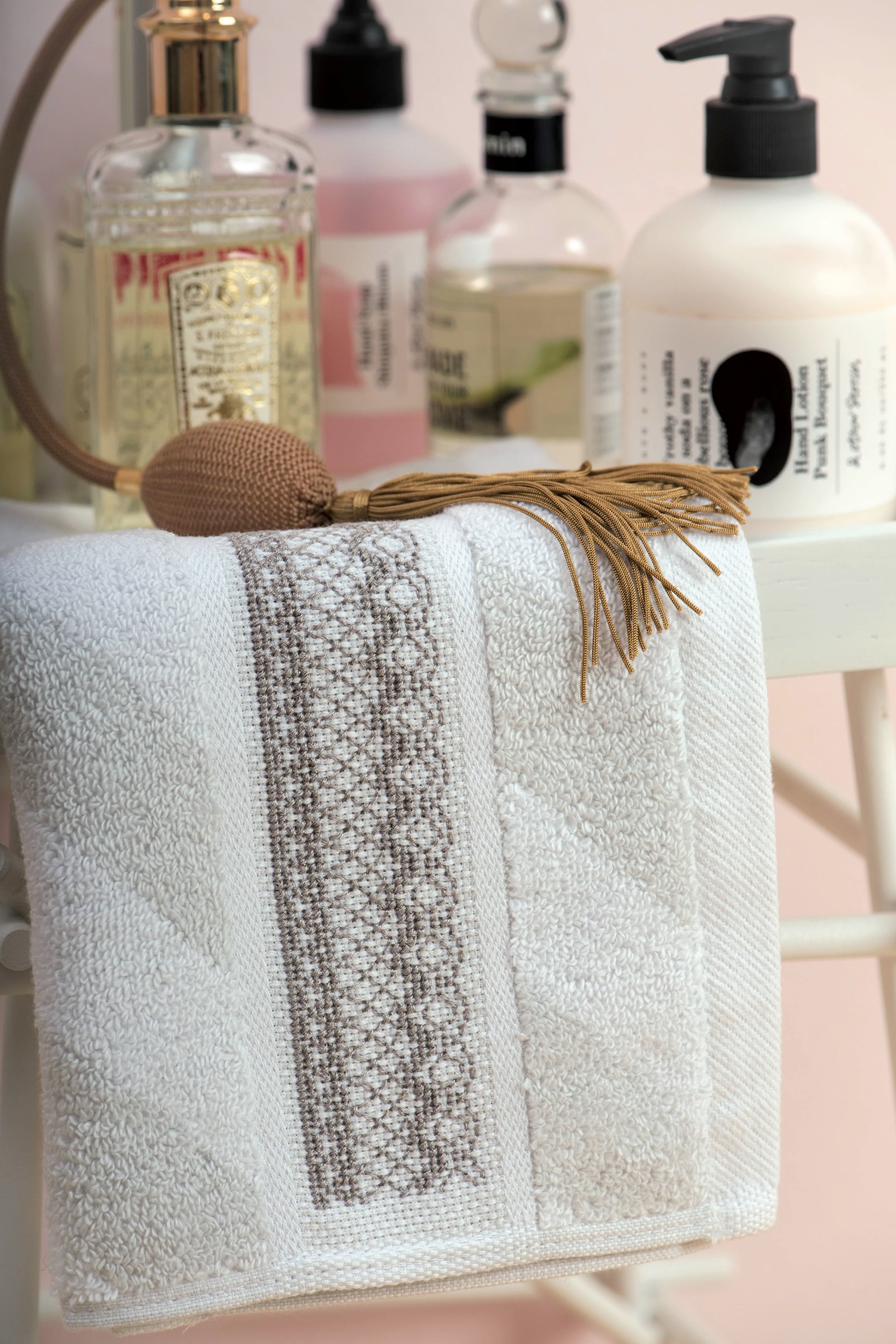 Grille de point de croix Linge de bain : dentelles et flacons de parfum sur Aïda 5,5 pts blanc. Plusieurs motifs inclus. Références DMC sur 6 pages.