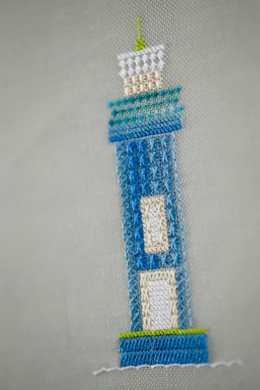 Grille de point de croix Évasion en bord de mer : phare, voilier et cabine sur lin 11 fils gris. 3 motifs inclus. Références DMC sur 6 pages.