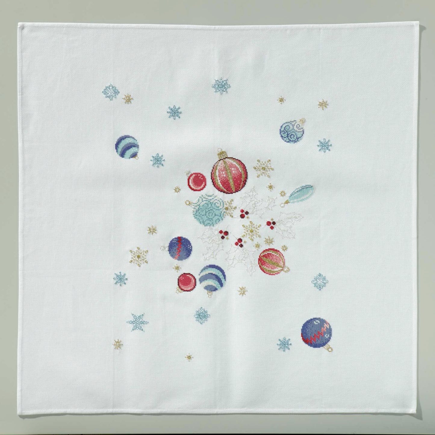 Grille broderie point de croix : nappe de Noël avec boules, flocons et étoiles. Imprimée en couleur sur 6 pages. Réf. DMC incluses.