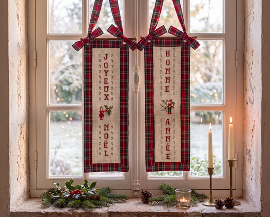 Brodez « Un air de fête à la fenêtre » : deux panneaux Joyeux Noël et Bonne Année, associés au tartan rouge, pour une décoration de fêtes chaleureuse.