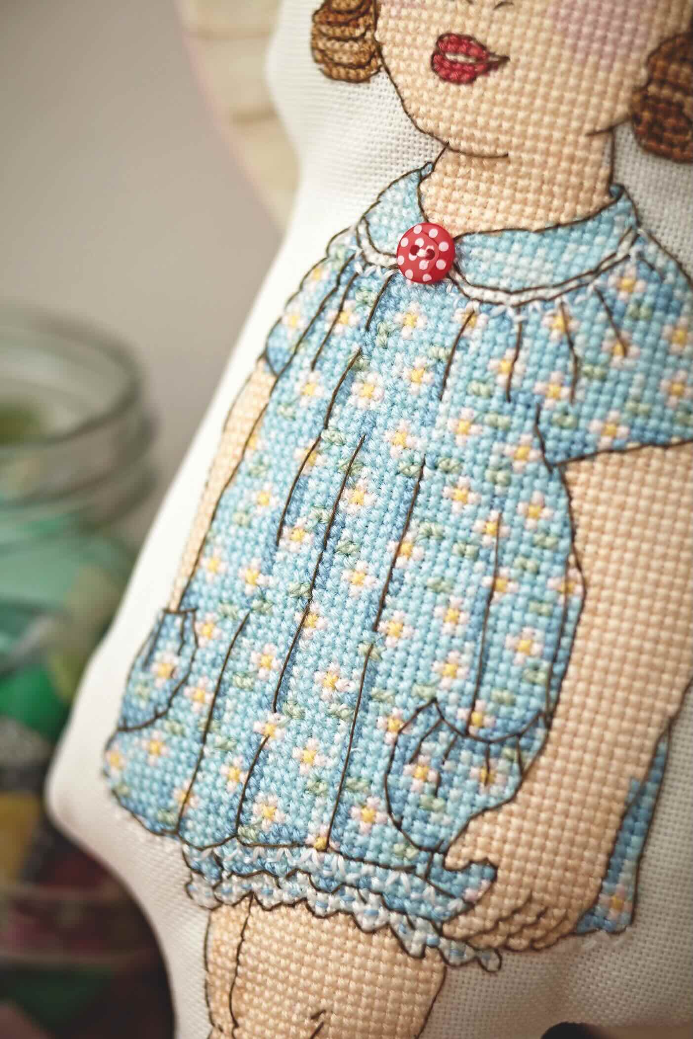 Grille broderie point de croix : poupée mignonette rétro pour enfants. Motif 9 x 26 cm, imprimée en couleur sur 4 pages. Réf. DMC incluses.