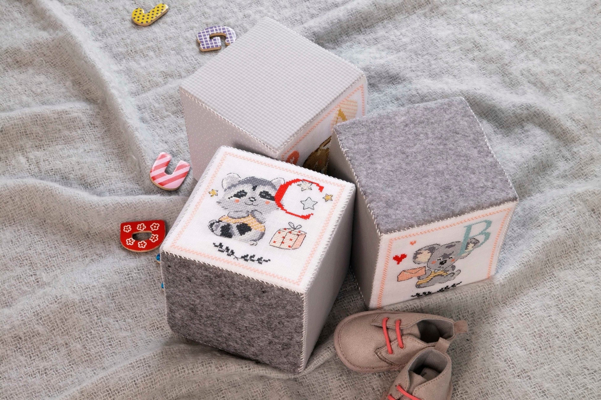 Grille de point de croix Tendres joujoux : cubes panda, lapinou et souricette sur lin 11 fils blanc. 29 x 108 points. Références DMC sur 6 pages.